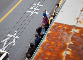 Restauracje na świecie, które słyną z jednego dania i ustawiają kolejki na godziny Kolejka ludzi stojących na przystanku autobusowym przy ruchliwej ulicy