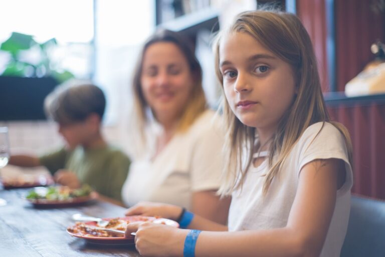 Rodzina w restauracji podczas posiłku, w centrum uwagi kilkuletnia dziewczynka