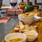 Góralskie oscypki i haute cuisine: kulinarna twarz Podhala na nowo Deska serów z winem i dipami na drewnianym stoliku