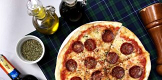Z widelcem przez Toskanię – gdzie naprawdę dobrze zjeść w Italii Pizza pepperoni i kieliszki czerwonego wina na kraciastym obrusie