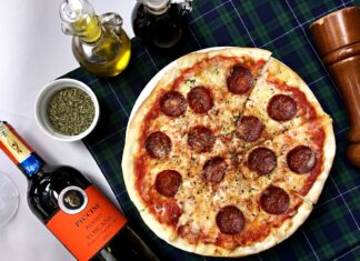 Z widelcem przez Toskanię – gdzie naprawdę dobrze zjeść w Italii Pizza pepperoni i kieliszki czerwonego wina na kraciastym obrusie