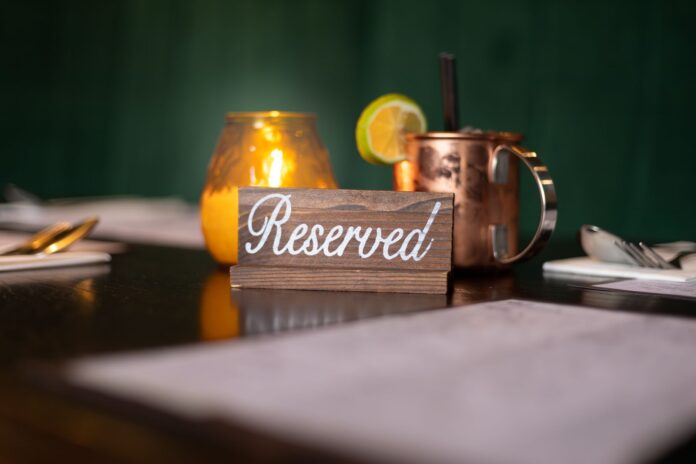 Zarezerwowany stolik w ciepłym świetle świecy w eleganckiej restauracji Zarezerwowany stolik w ciepłym świetle świecy w eleganckiej restauracji